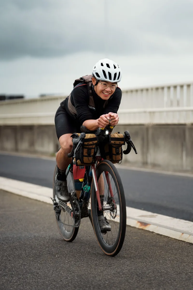 Cyclist riding a bike fitted with Merit Gear bags
